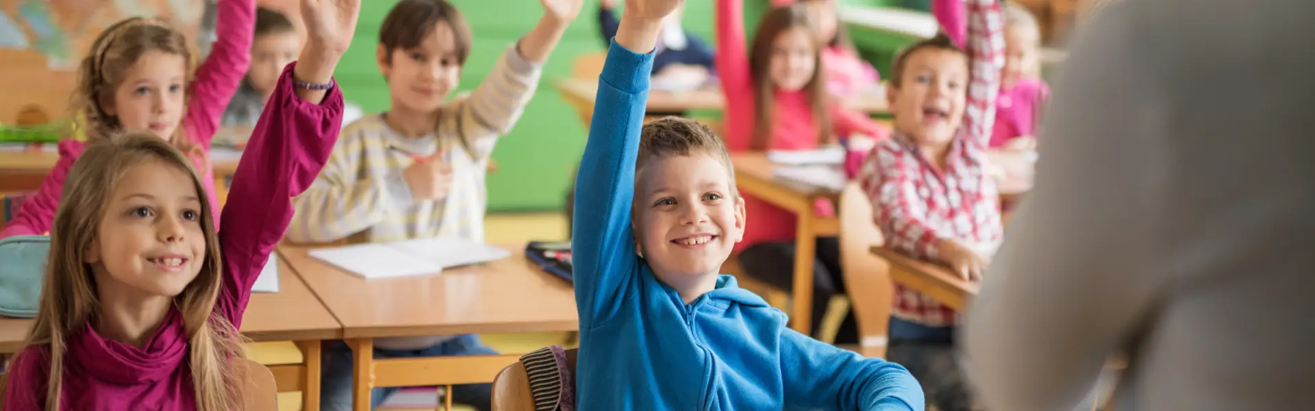 Dzieci w klasie podnoszące ręce